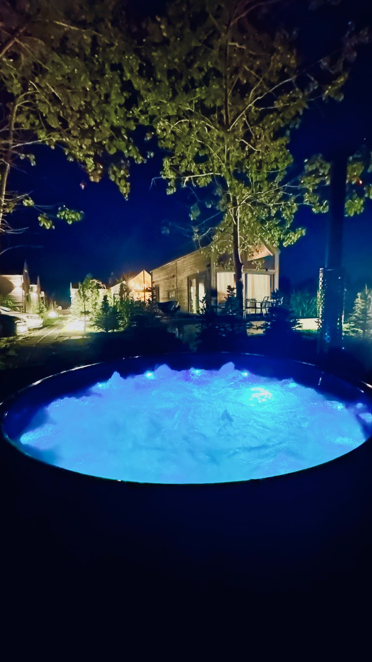 Balia z fioletowym LED nocą na tle resortu