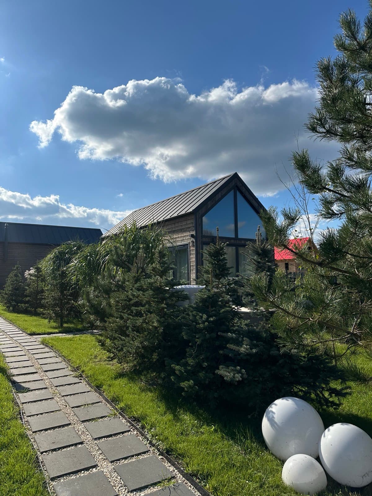 Domek A-frame w otoczeniu zieleni — widok z boku